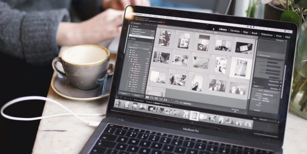 MacBook Pro beside white cup