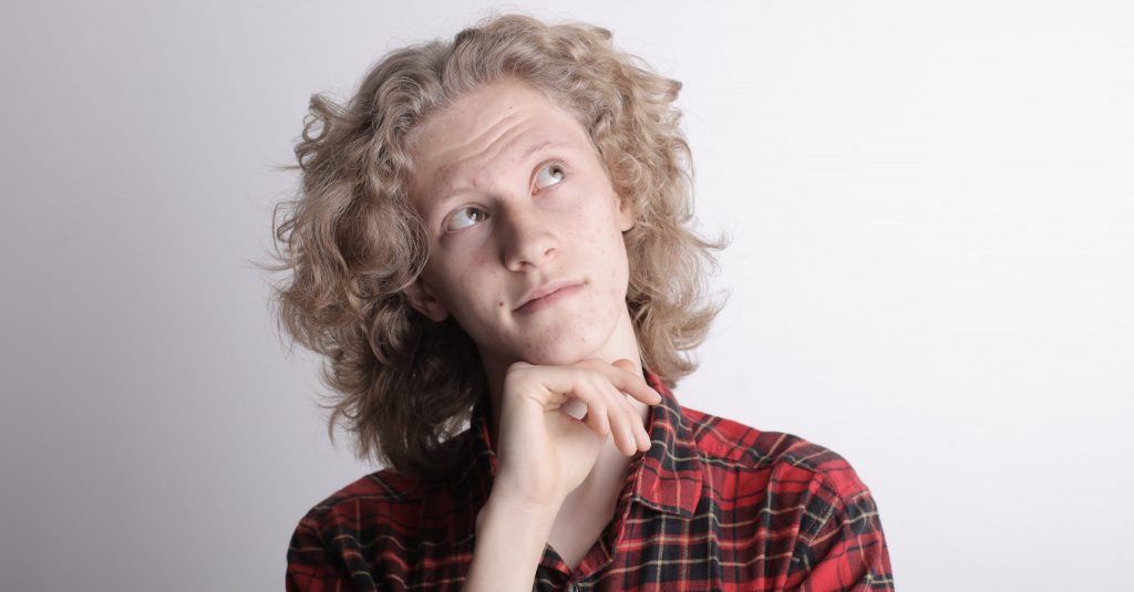 Pensive male teen on gray background