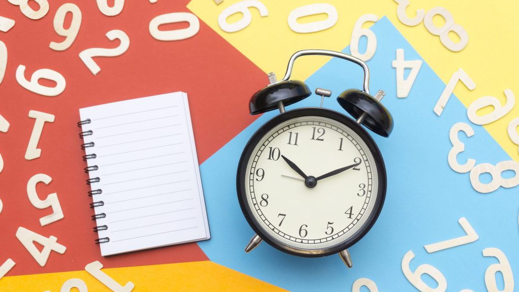 Alarm clock lying on multicolored surface