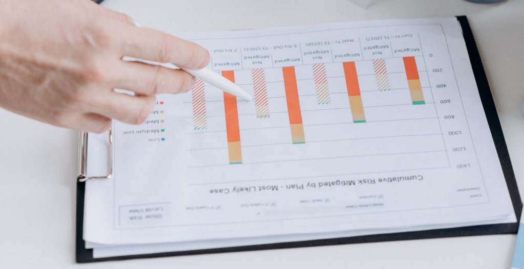 Close up photo person pointing at a statistical graph in a clipboard