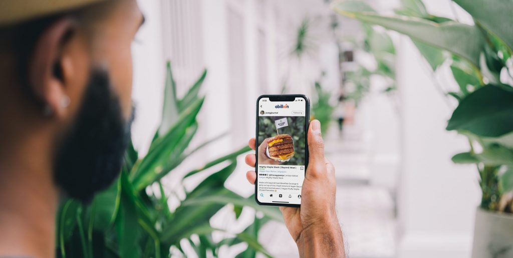 Man looking at a review of a Beyond Burger on the abillion app