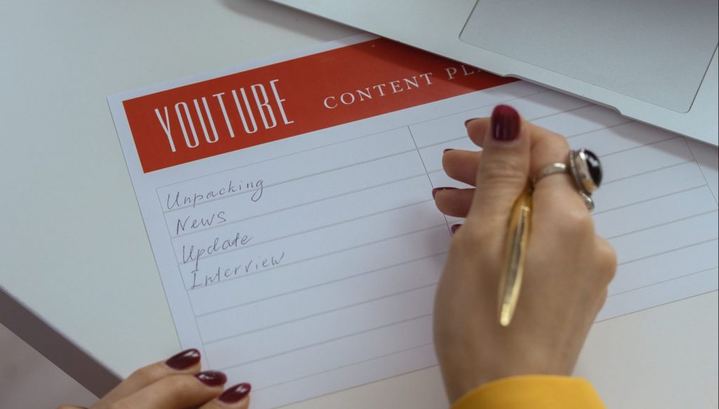 Person in gold ring holding white paper