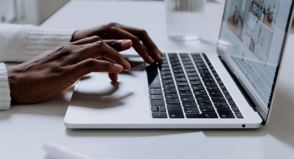 Person using macbook pro on white table