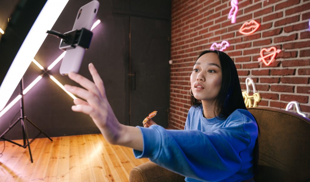 A woman using her phone while attached on a ring light