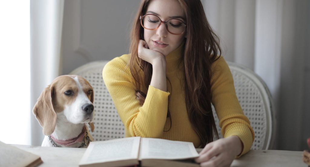 Woman in yellow sweater while reading a book