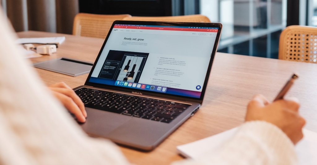 A man working on his laptop computer in an office viewing Zyro website