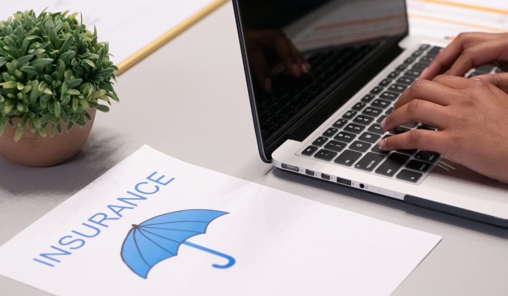 A paper beside a person typing on a laptop