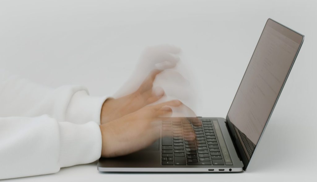 Hands typing on a laptop keyboard