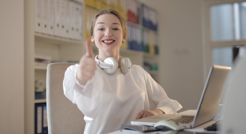 Woman in office thumbs up