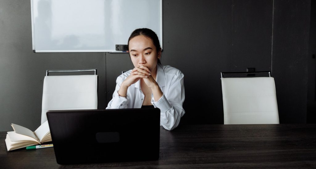 Woman thinking while looking at laptop