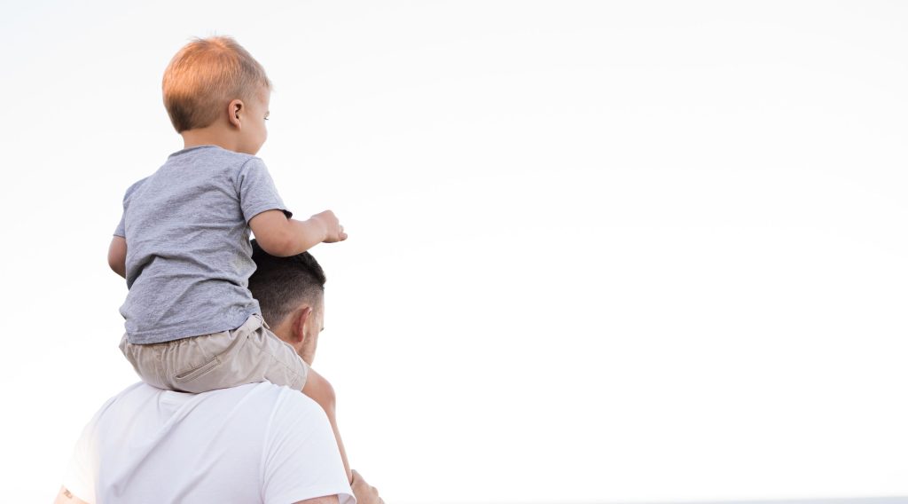 man in white shirt carrying boy