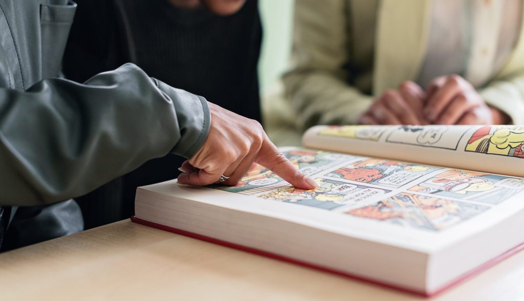 Person pointing on an illustration in a book