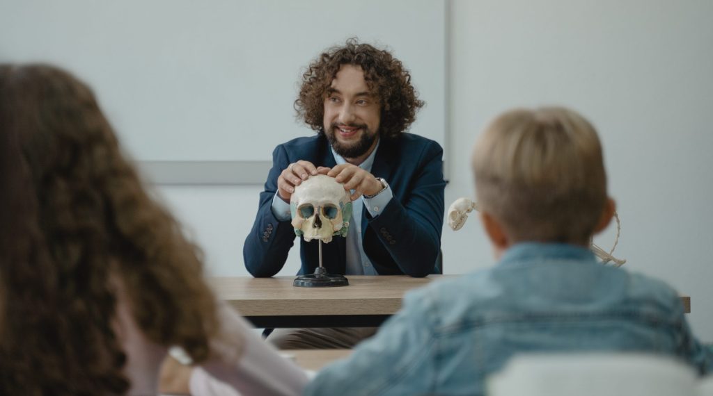 Teacher showing his class a human skull