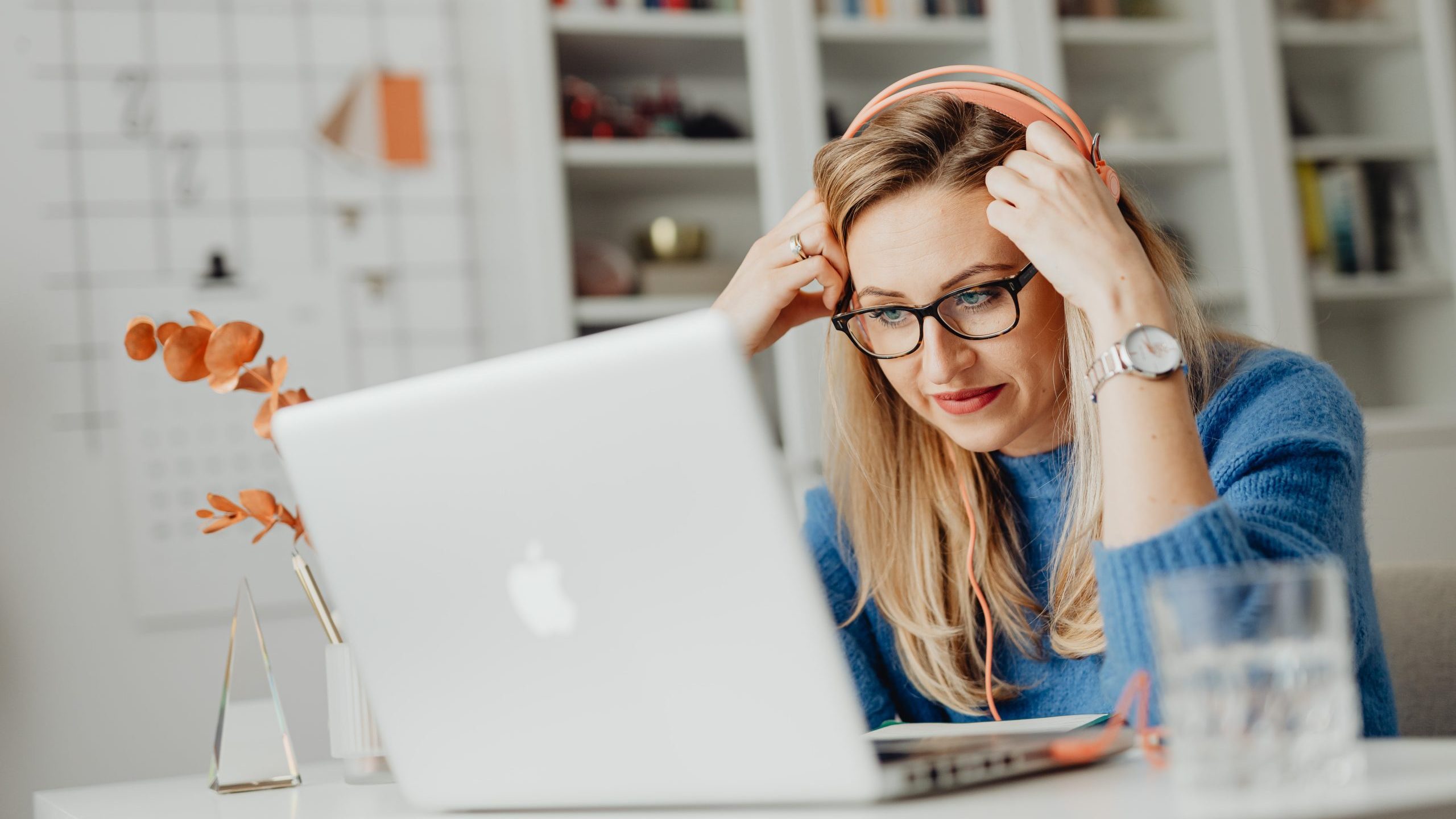 Woman wearing a knitted sweater watching on a laptop