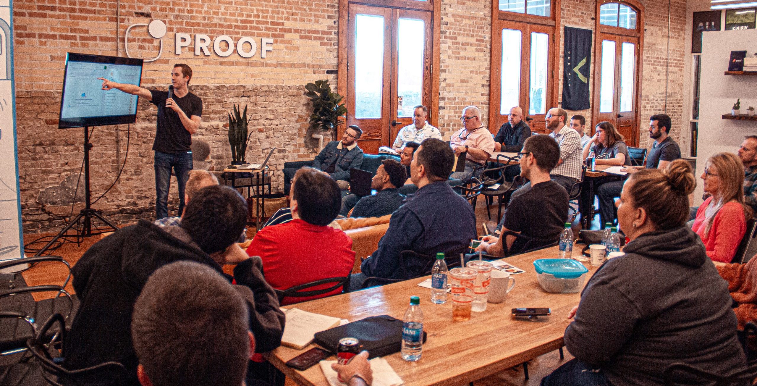 Man presenting power point to small audience in start-up office.